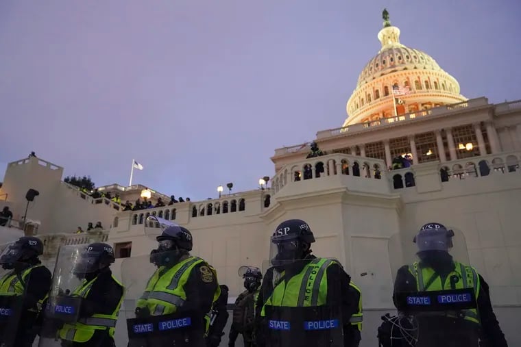 In this Jan. 6 photo, police form a line to guard the Capitol after violent rioters stormed the Capitol.