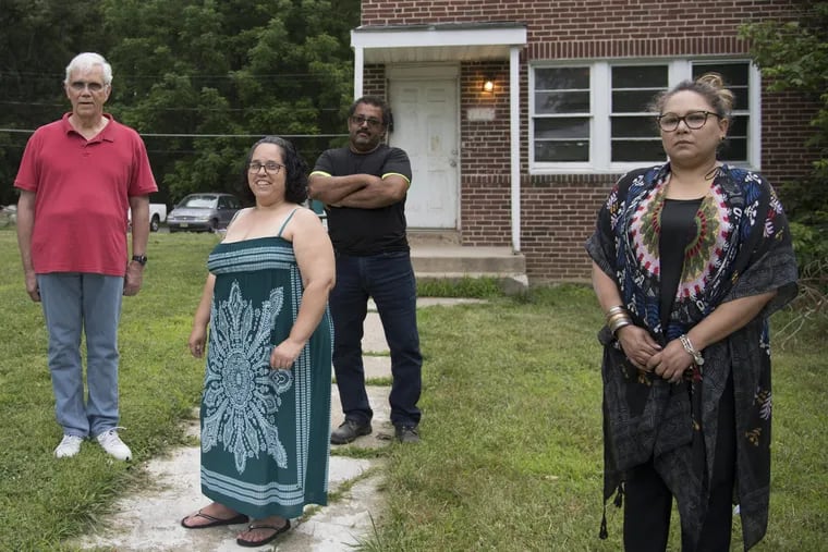 Mount Holly Gardens residents, (from left) James Potter, Beatriz Cruz, Santos Cruz and Rebecca Gonzalez, stand in front of Santos Cruz' home at the Mount Holly Gardens in Mt. Holly, N.J.  Years ago they filed a lawsuit  claiming bias discrimination saying their neighborhood was comprised of mostly minorities and they would be displaced by a redevelopment project.