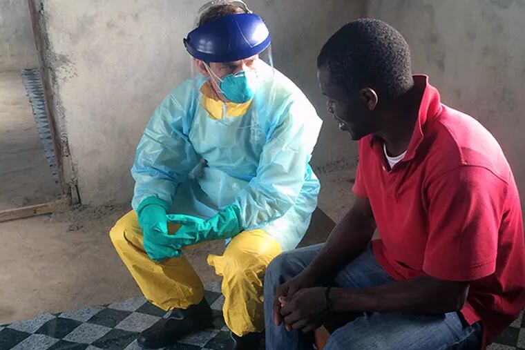 Dan Kelly explains to a patient suspected of having Ebola why Dan wears protective gear. Kelly returned to the University of California - San Francsico this week after a month in the West African country, epicenter of the Ebola outbreak. (courtesy photo)