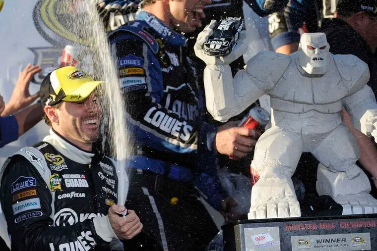 Jimmie Johnson pops the cork after winning the AAA 400 and moving into second place in the Cup Chase.(Associated Press)