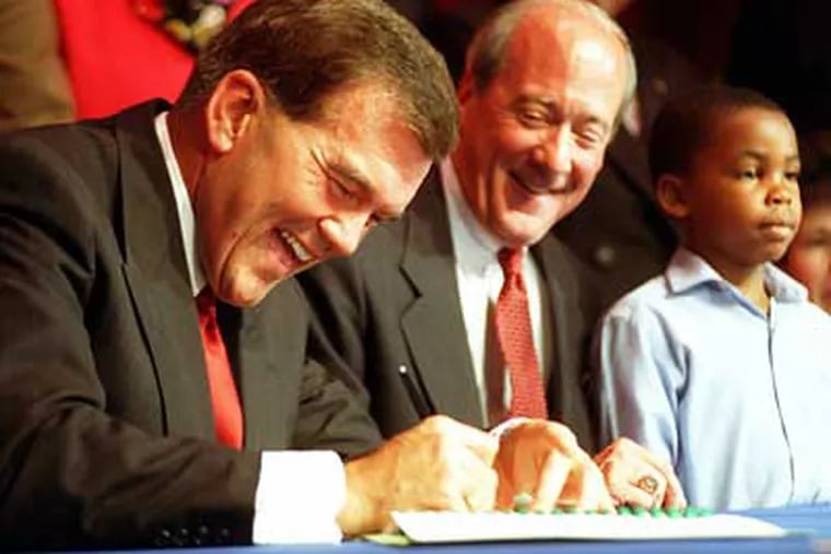 Gov. Tom Ridge is more than glad to sign the "PA. Charter School" bill, Senate Bill No. 123, at a forum on charter schools held at the Free Library of Philadelphia in June 1997.  (Staff File Photo)