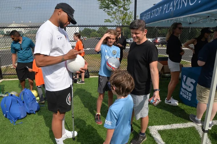 Zack Steffen signs a ball for 7-year-old Isaac MacKale of Coatesville as his 11-year-old brother, Luke, and father, Joseph, look on.