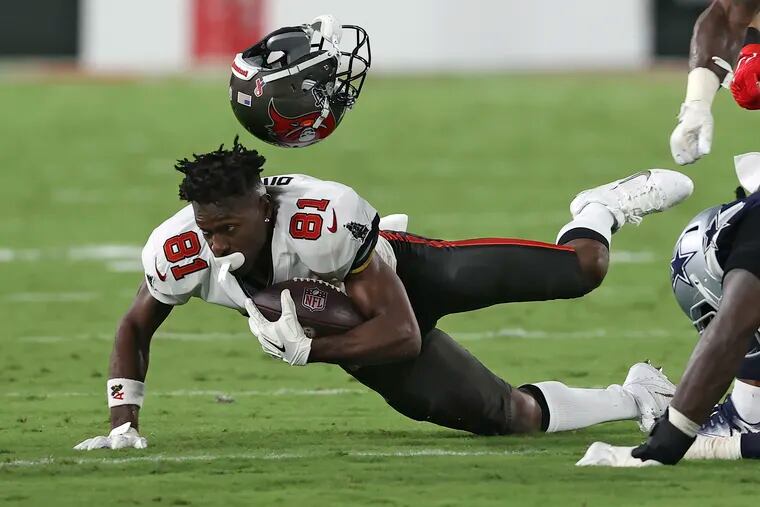 Tampa Bay Buccaneers wide receiver Antonio Brown loses his helmet vs. Dallas back on Sept. 9. He'll lose $330,000 in salary during a three-game suspension for submitted false COVID-19 documentation.