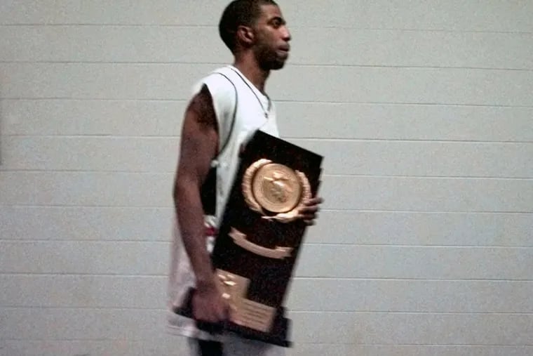 Connecticut's Richard Hamilton, a former Coatesville High star, carries the NCAA championship trophy after the Huskies defeated Duke, 77-74, in 1999.