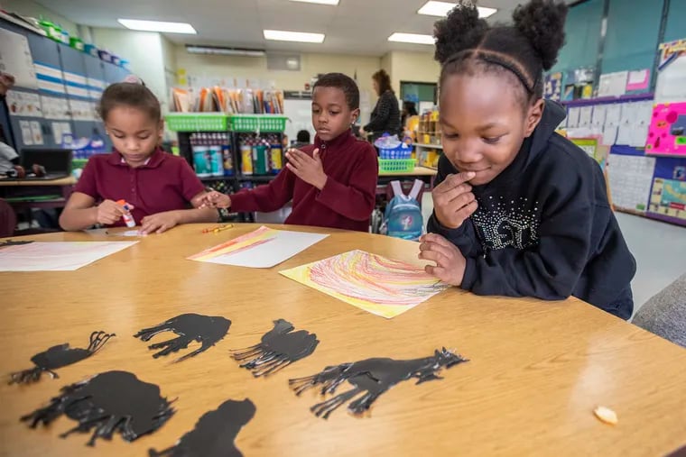 Nasihah Travers, 7, right, can’t decide what safari animals she wants to paste onto her African grasslands art project, in Tamar LaSure-Owens class at Leeds Avenue Elementary School in Pleasantville.