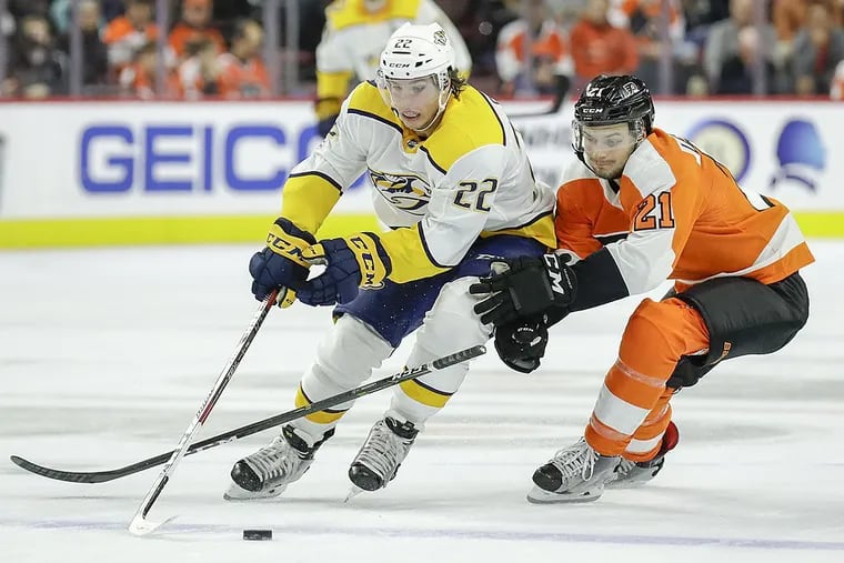 Flyers center Scott Laughton goes after the puck against Predators left wing Kevin Fiala.