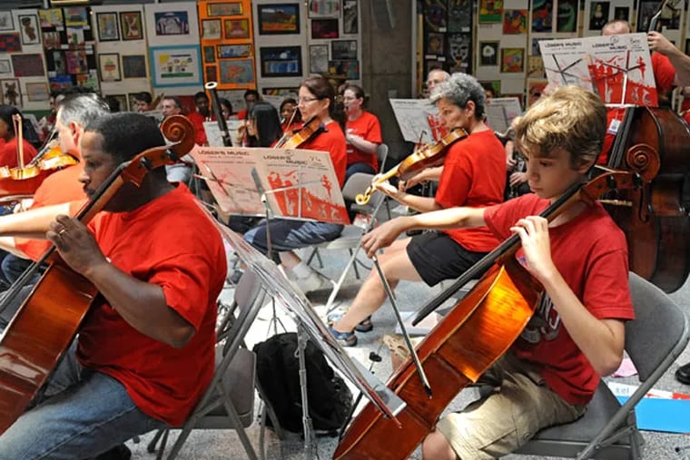 Phineas Shapiro, 15, a sophmore at Masterman High, plays the cello
with The Philadelphia All-City Orchestra, made up mostly of school
district instrumental music teachers and some students, at a farewell
concert June 24, 2013 in the atrium at School District Headquarters on
N. Broad St.  In the current school district budget, school music
teachers will be laid off and music programs eliminated. ( CLEM
MURRAY / Staff Photographer )
