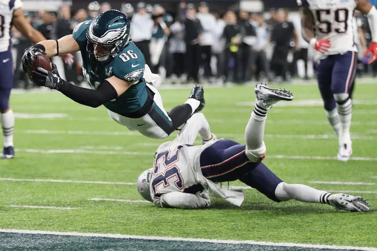 Eagles tight end Zach Ertz dives over New England Patriots defensive back Devin McCourty to score the winning touchdown in the fourth quarter of Super Bowl LII, at U.S. Bank Stadium in Minneapolis, Minnesota, Sunday, Feb. 4, 2018. The Eagles won 41-33. TIM TAI / Staff Photographer