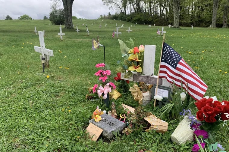 Flowers and sign mark the grave of Evelyn Colon and her unborn daughter, Emily Grace, at a Potter's Field in Carbon County, Pa. Authorities have charged a former boyfriend with homicide for 1976 murder.