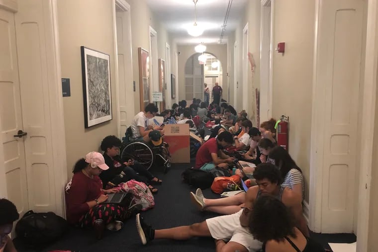 Dozens of Swarthmore College students sit outside the school president's office on Thursday, May 2. They want her to permanently ban two fraternity organizations from campus.