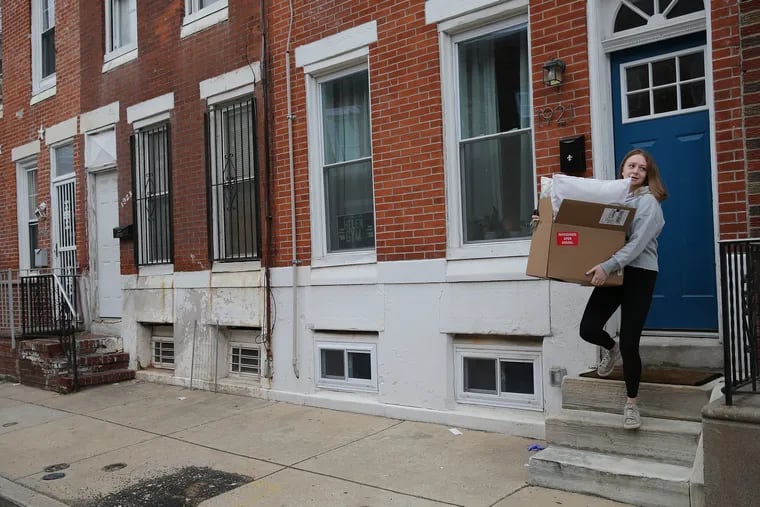 Melissa McCleery, who is in the process of moving from one house to another during the coronavirus pandemic, carries her pillows to her vehicle in Philadelphia, on March 30, 2020.