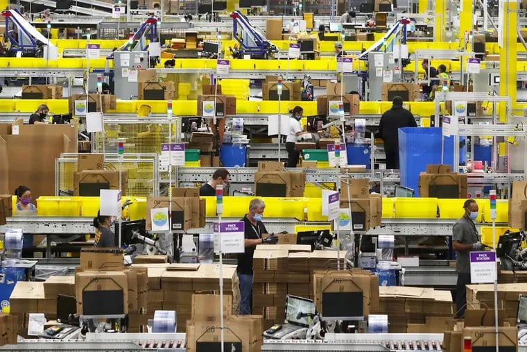 Employees work at packing stations at Amazonâ€™s Kent fulfillment center in June 2020.