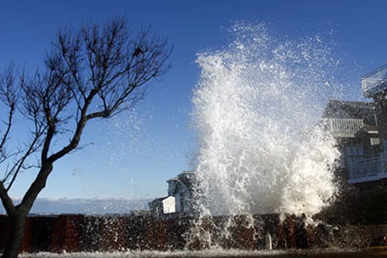 Waves crash against a retaining wall behind a house on Seaview Ave. in Strathmere. The wall was recently erected, one of the stop gap measures being used to try to strengthen the eroding shore line there. (Eric Mencher / Staff Photographer)