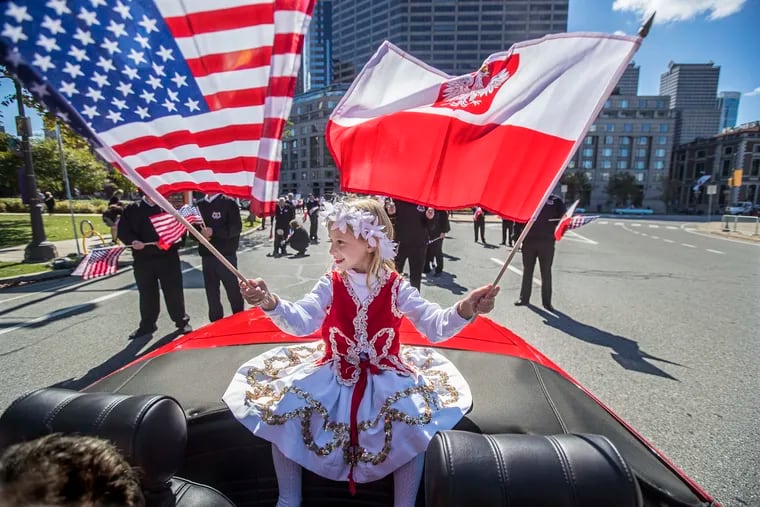 Grace Rachubinski, 6, sitting in the back of a red Thunderbird and representing the 2nd Street Polish Society, waves her Polish and American Flags as she makes her way around Logan Circle on Sunday October 1, 2017 as part of the Pulaski Day Parade was on the Benjamin Franklin Parkway.