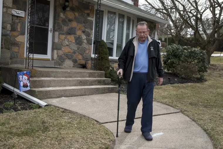 Inquirer sports columnist emeritus Bill Lyon, diagnosed with Alzheimer’s, tests out his new cane outside his Broomall home.