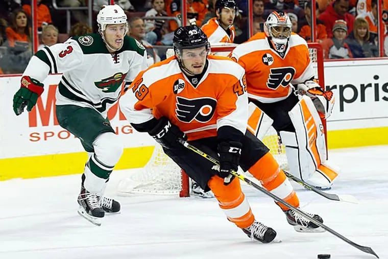 Scott Laughton skates with the puck past goalie Ray Emery and the Wild's Charlie Coyle. (Yong Kim/Staff Photographer)