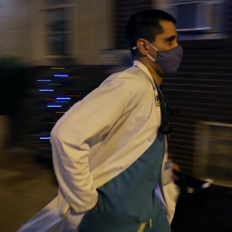 Nurse practitioner Tarik Khan rushes back to his car after vaccinating a woman in South Philadelphia with an unused COVID-19 vaccine dose in 2021. Khan spent the entire evening administering unused vaccine doses to homebound individuals and their caretakers.
