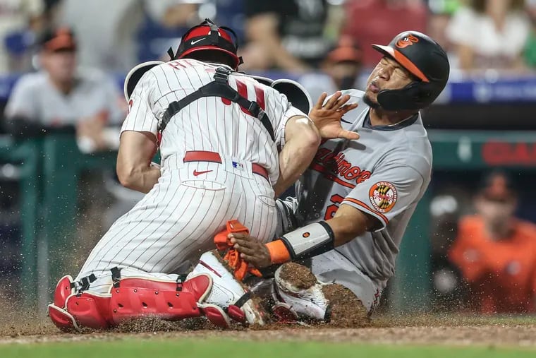 Phillies catcher J.T. Realmuto tags  out the Orioles' Pedro Severino at home plate during the eighth inning.