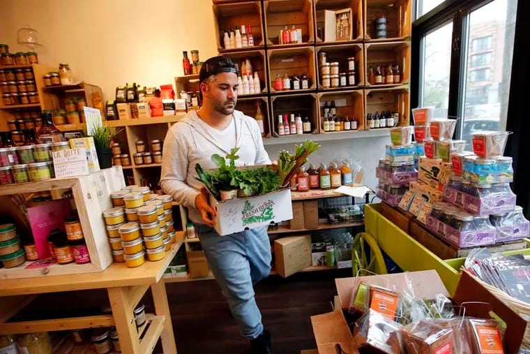 Adam Erace carries a prepared box of CSA food at Green Aisle Grocery on April 29, 2016.  Erace is a co-owner of store.