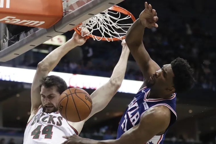 Bucks big man Tyler Zeller is fouled by Sixers center Joel Embiid as he dunks during the second half of the Sixers’ loss on Sunday.