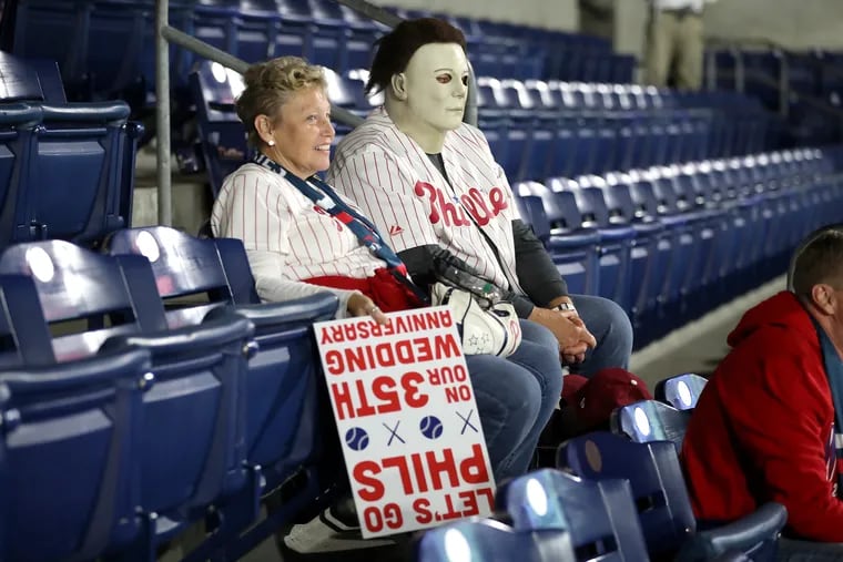 Maryjane and James Dambach of Philadelphia sit in the stands after Game 3 of the World Series between the Phillies and Astros was postponed at Citizens Bank Park.