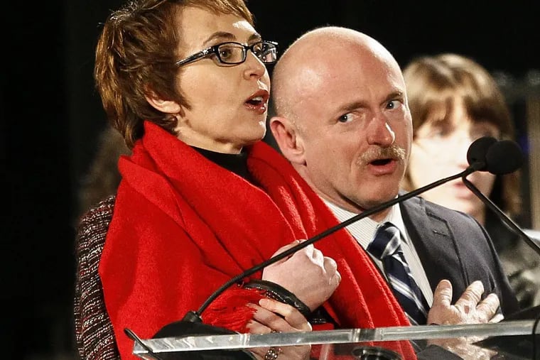 In this Jan. 8, 2012, file photo, Rep. Gabrielle Giffords, left, leads the Pledge of Allegiance accompanied by her husband, former astronaut Mark Kelly, at the start of a memorial vigil remembering the victims and survivors of the shooting that wounded Giffords, a dozen others and killed six.