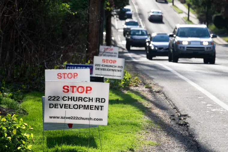 Signs like these on Church Road have become common in and around the Elkins Park neighborhood in Cheltenham Township, where the prospect of five wooded acres being replaced by eight new single-family homes has raised concerns about additional stormwater runoff into the flood-prone Tookany Creek.