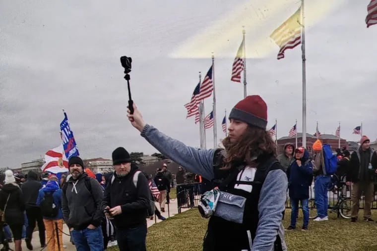 A man prosecutors have identified as James Rahm III, of Atlantic City, films the crowd outside the U.S. Capitol in Washington on Jan. 6, 2021.