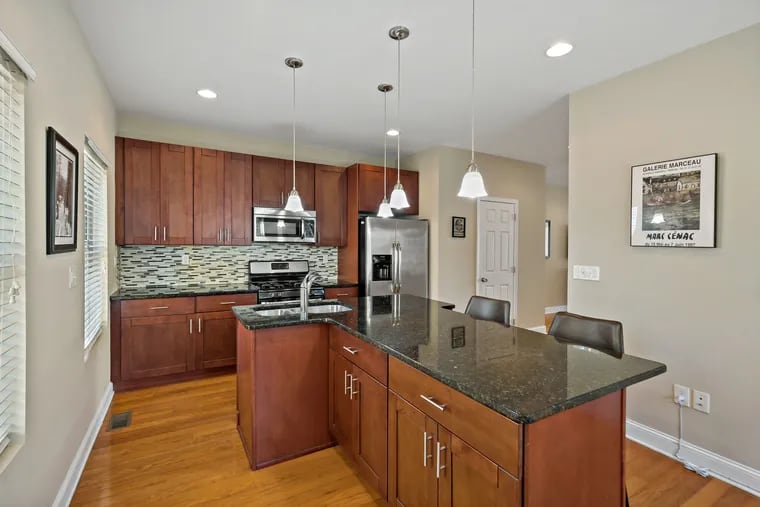 The kitchen has granite countertops, stainless steel appliances, and a large island.