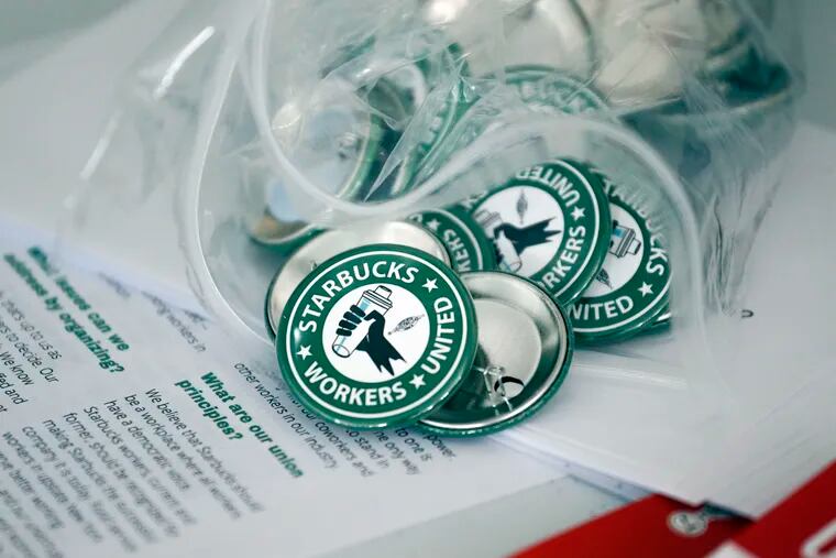 Pro-union pins sit on a table during a watch party for a Starbucks' employees union election last year in Buffalo, N.Y.