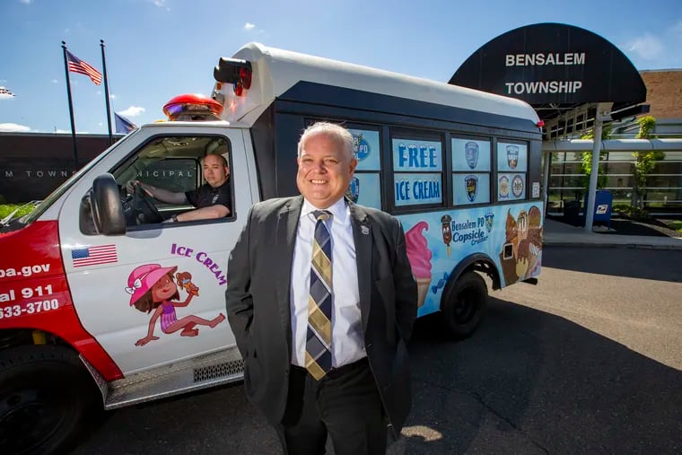 Bensalem Township Police Director Fred Harran (front) and Police Sgt. Greg Winokur (behind the wheel) pose with the Bensalem Police Department's new ice cream truck — aka the Copsicle Cruiser — a converted school bus manned by police officers who dispense free ice cream to the public.
