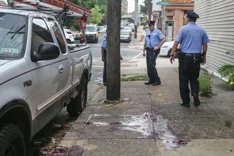 Philadelphia Police investigate a blood soaked sidewalk at the shooting scene at 16th and Clearfield where one man is dead and another critical. Friday, July 5, 2018.