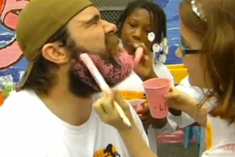 Eagles center Jason Kelce lets students from Comegys Elementary School paint his beard pink.