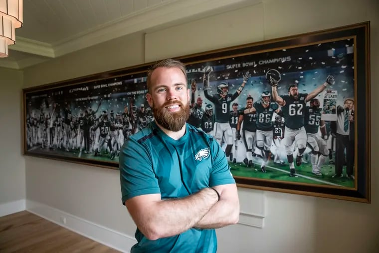 Artist Jordan Spector stands in front of his Eagles painting, commissioned by Rob Schimek, called "On the Road to Victory."