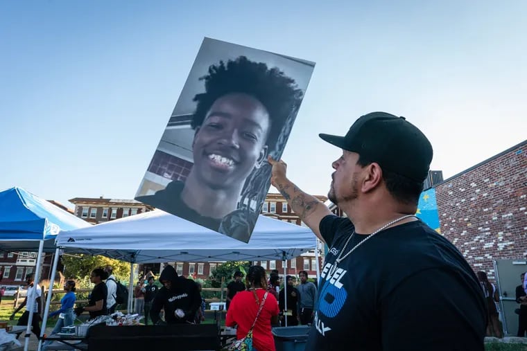 Aaron Campbell, Founder and Executive Director of Level Up, holds a photograph of 12-year-old Hezekiah Bernard, who was shot and killed, and discarded in a dumpster in West Philadelphia.