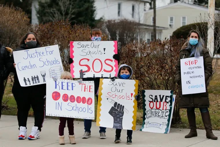 In this file photo, protesters hold a rally at Sharp Elementary School holding signs to save Camden, New Jersey public school.  Sharp is among three schools slated to close.