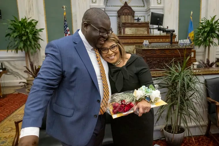 Newly sworn-in Council members Anthony Phillips and Quetcy Lozada embrace at the end of a swearing-in ceremony in City Council Chambers on Monday.