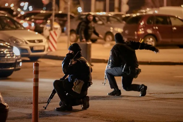 Ukrainian police rush a traveler to the railway station terminal during an airstrike alarm in Kyiv, Ukraine, Monday, Feb. 28, 2022.