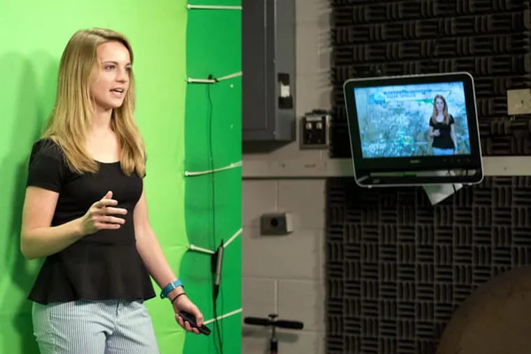 Sophomore Casey Lehecka gives a weather report in front of a green screen in the department’s TV studio. She mistakenly wore a green scarf her first time out. (KELSIE NETZER / For The Inquirer)