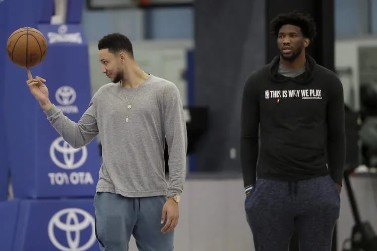 The Sixers’ Ben Simmons spins the basketball on his finger next to teammate Joel Embiid after Markelle Fultz worked out for the Sixers at their training complex in Camden on Saturday.