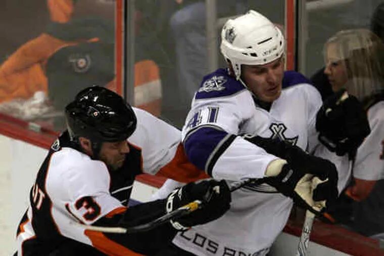 Flyers&#0039; Glen Metropolit drives the Kings&#0039; Raitis Ivanans into the boards during the first period.