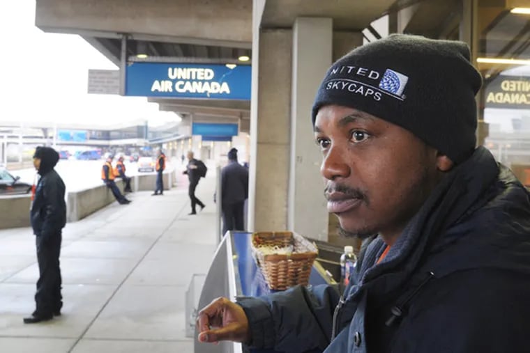Skycap Brahim Alexander waits outside Terminal D at Philadelphia International. (Clem Murray / Staff Photographer)