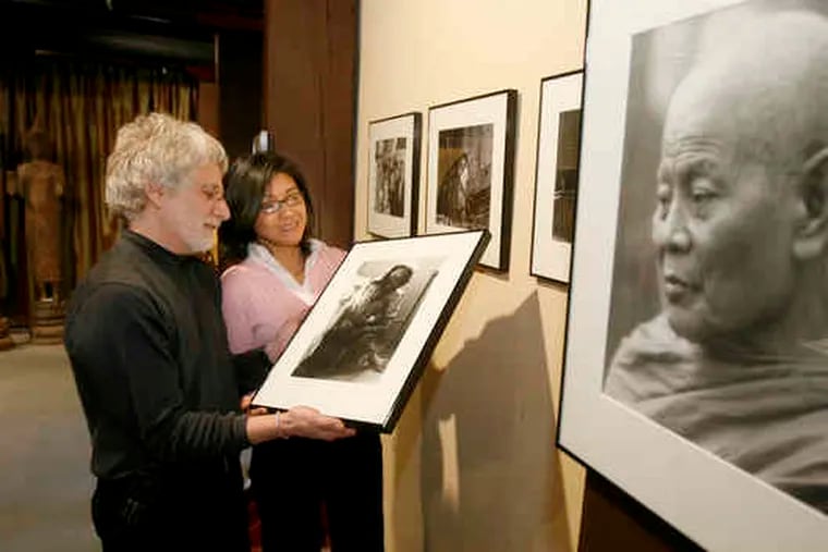 Photographer Mario Nascati Jr. and Bonna Neang Weinstein, owner of Khmer Art Gallery, look over a photograph from Nascati's archives.