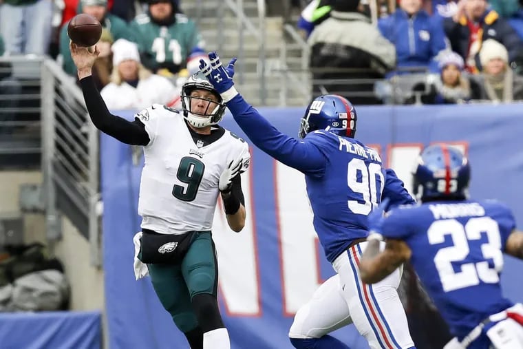 Eagles quarterback Nick Foles gets rid of the football past New York Giants defensive end Jason Pierre-Paul and defensive back Darryl Morris in the second-quarter on Sunday, December 17, 2017. YONG KIM / Staff Photographer