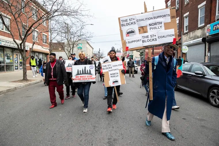 Reuben Jones (center), executive director of Frontline Dads, marches against gun violence with a group on Susquehanna Avenue in Philadelphia on Monday. He organized a rally and march, and called on the city to  give more money to antiviolence groups.