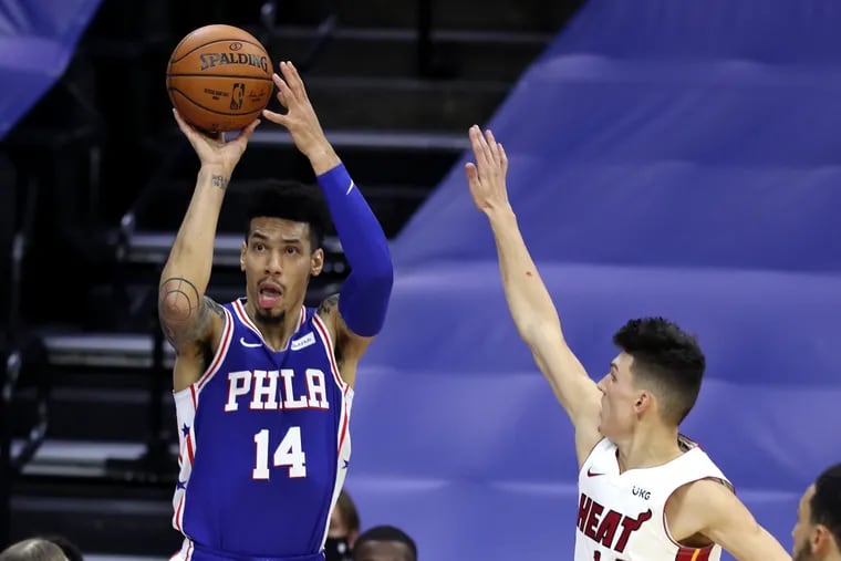 Danny Green, left, of the SIxers shoots a 3-pointer against Tyler Herro of the Heat during the 1st half of a NBA game at the Wells Fargo Center on Jan. 12, 2021.