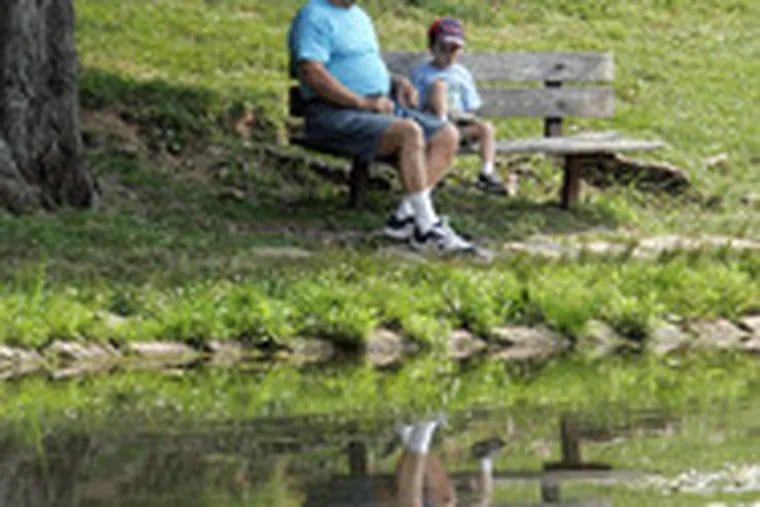 All is calm - on the surface. But Herman Maurer and his 3-year-old grandson, Casey, nevertheless keep a respectful distance from the water&#0039;s edge yesterday at Masons Mill Park.