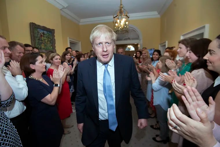 Britain's New Prime Minister Boris Johnson is welcomed into 10 Downing Street by staff, in London, Wednesday, July 24, 2019. Britain's new Prime Minister Boris Johnson has vowed the U.K. will leave the European Union on Oct. 31 — "no ifs, ands or buts." Speaking just moments after Queen Elizabeth II asked him to form a government Wednesday, Johnson sought to persuade the public to back him — saying that the time has come to act on the nation's departure from the European Union. (Stefan Rousseau/Pool Photo via AP)