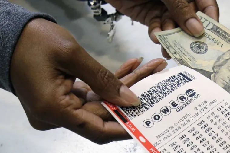 A clerk hands over a Powerball ticket for cash.