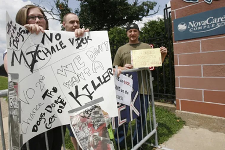 Karrie Geiger, left and husband, Brian, and David Boulden, right, protest the signing of quarterback Michael Vick by the Eagles this morning at the entrance to the NovaCare Complex in South Philadelphia. (Alejandro A. Alvarez / Staff Photographer)
